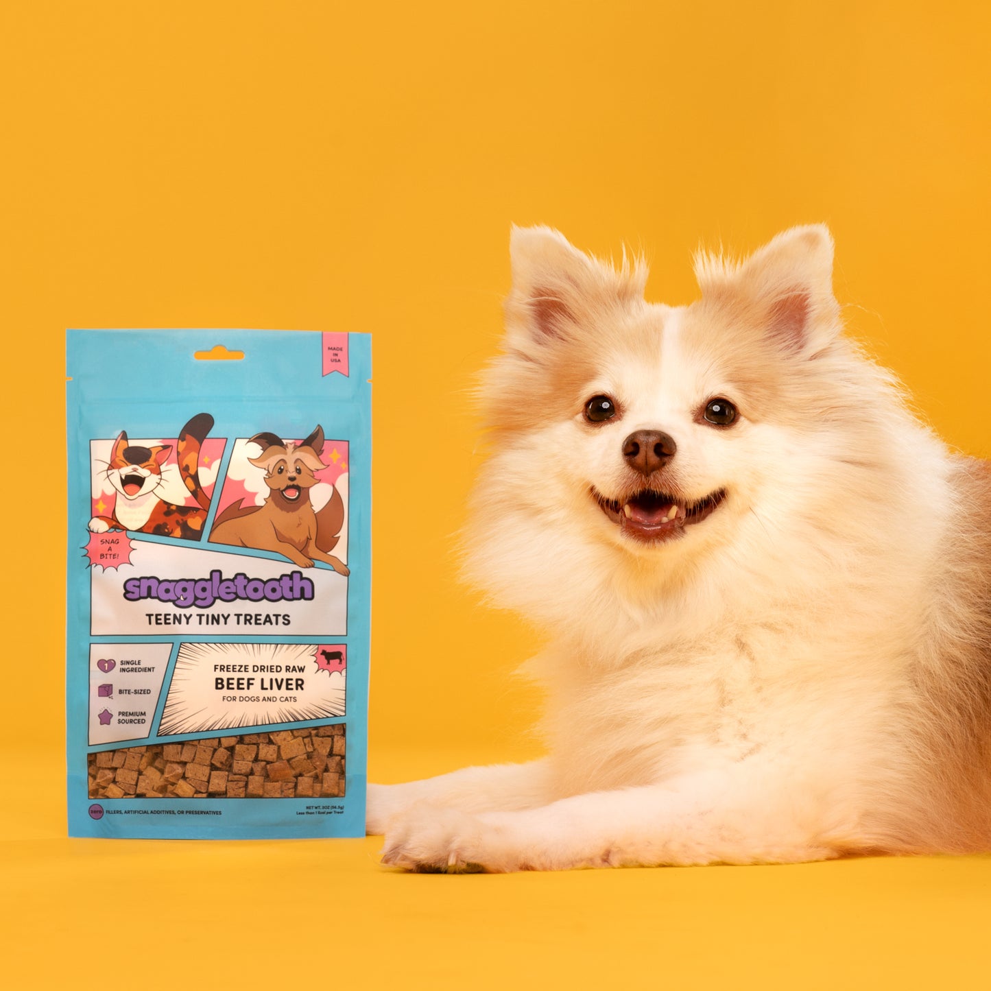 a bag of snaggletooth freeze dried beef liver treats next to a white dog